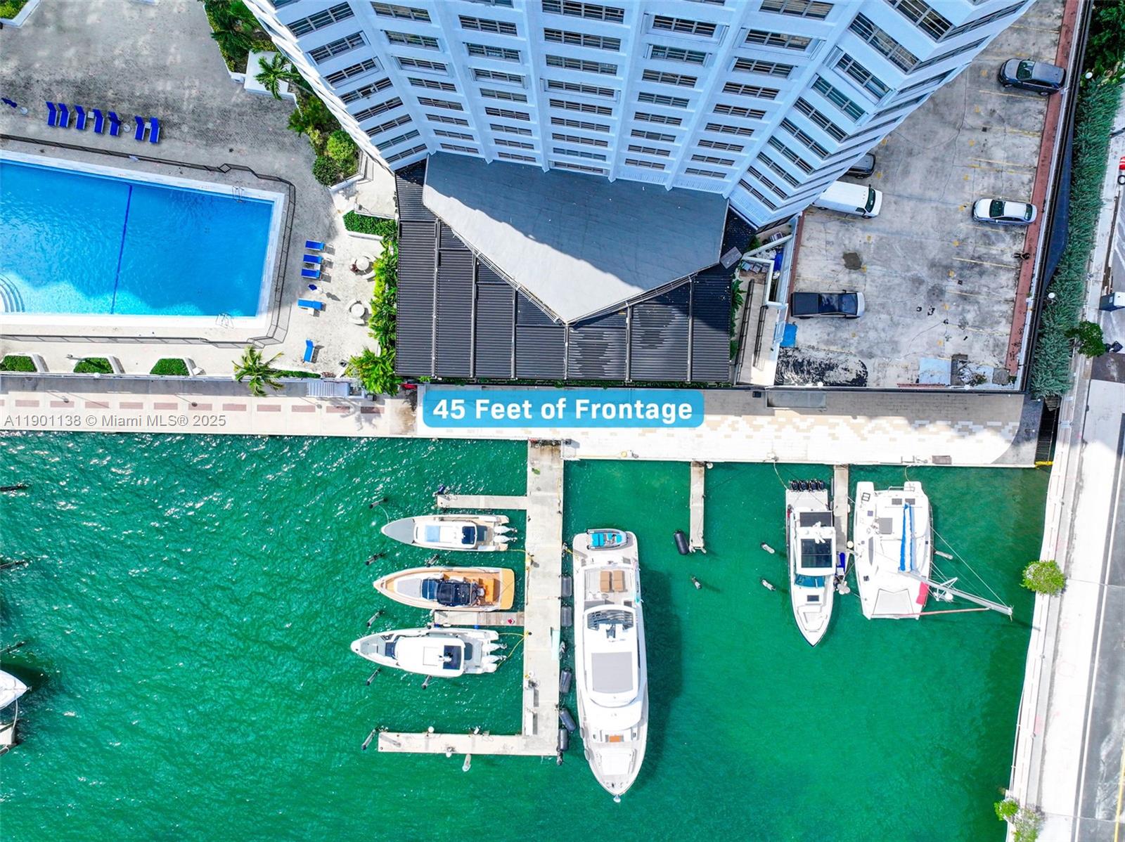 An aerial view shows a waterfront building with a pool, parking, and a boat dock — 801 Brickell Bay Dr, Miami FL 33131, MIAMI, FL