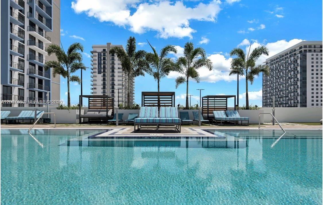 A swimming pool with lounge chairs and cabanas sits in front of tall apartment buildings — 5350 NW 84th Ave # 512, Doral FL 33166, DORAL, FL