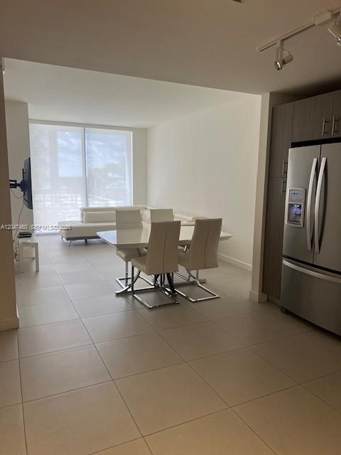 A modern dining area features a white table and chairs adjacent to a stainless refrigerator — 5350 NW 84th Ave # 512, Doral FL 33166, DORAL, FL