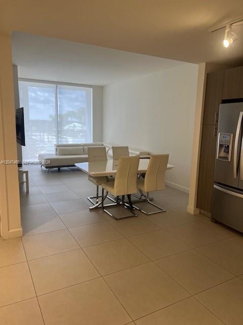 A dining area with a white table and chairs sits in front of a living room — 5350 NW 84th Ave # 512, Doral FL 33166, DORAL, FL