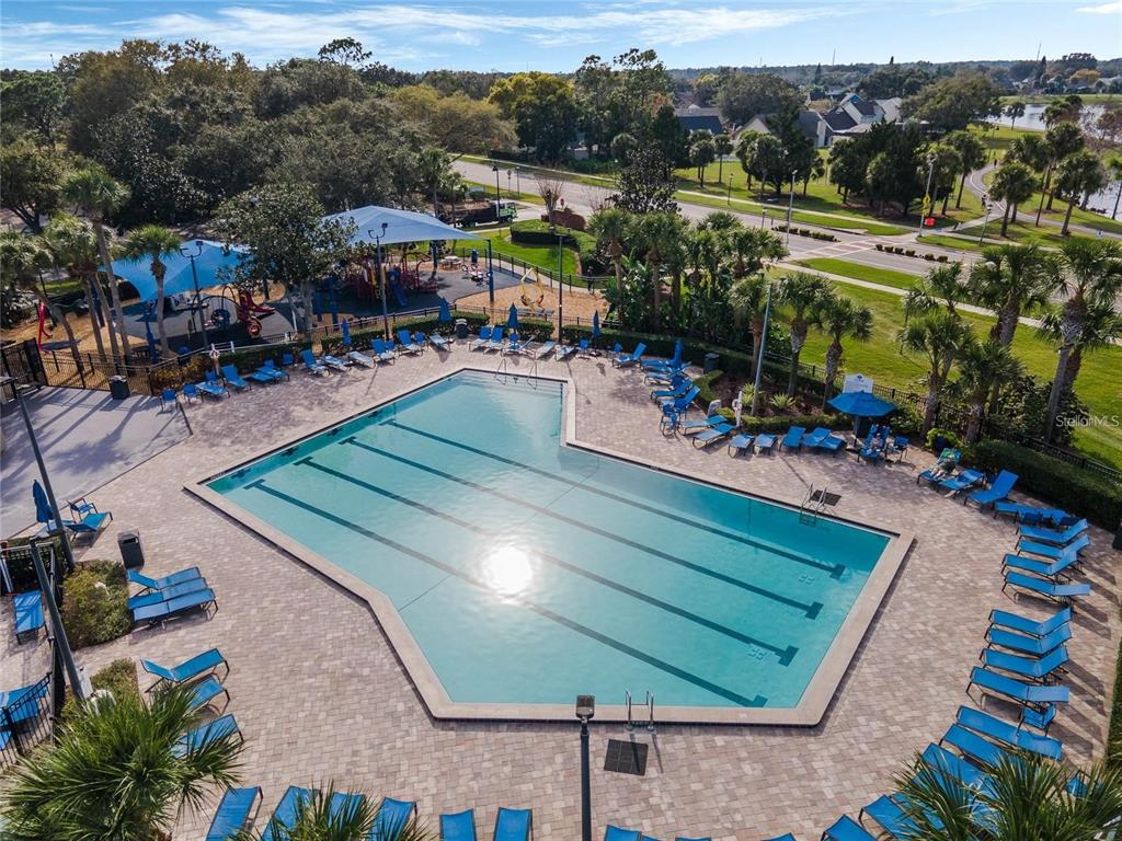 An aerial view shows a swimming pool with lounge chairs and a playground nearby — 1025 OCEANBREEZE COURT, ORLANDO, FL