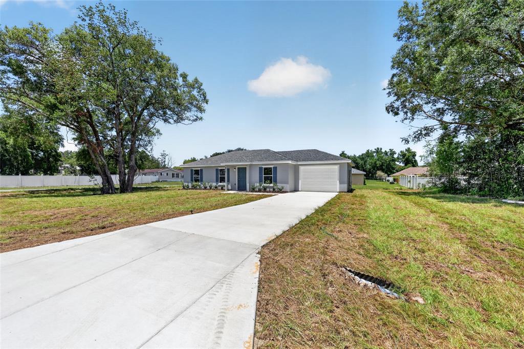 A single-story gray house with a white garage and a concrete driveway — 6747 SW 86TH PLACE, OCALA, FL