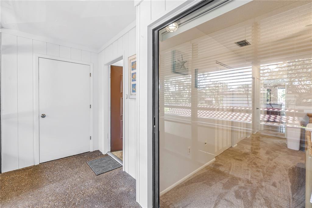 A carpeted entryway leads to a brown door and a glass-enclosed room with blinds — 3500 EL CONQUISTADOR PARKWAY UNIT 108, BRADENTON, FL