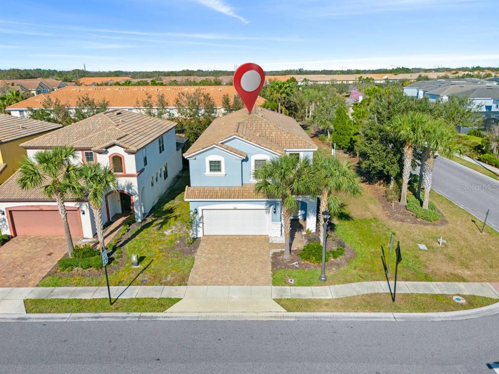 An aerial view shows a two-story blue house with a tiled roof and a driveway — 5405 MISTY OAK CIRCLE, DAVENPORT, FL