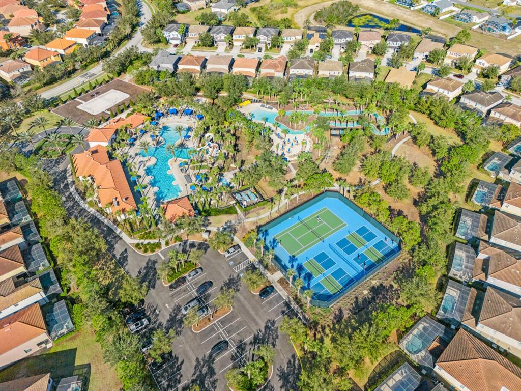 Aerial view of a community recreation center featuring a swimming pool, tennis courts, and parking — 5405 MISTY OAK CIRCLE, DAVENPORT, FL
