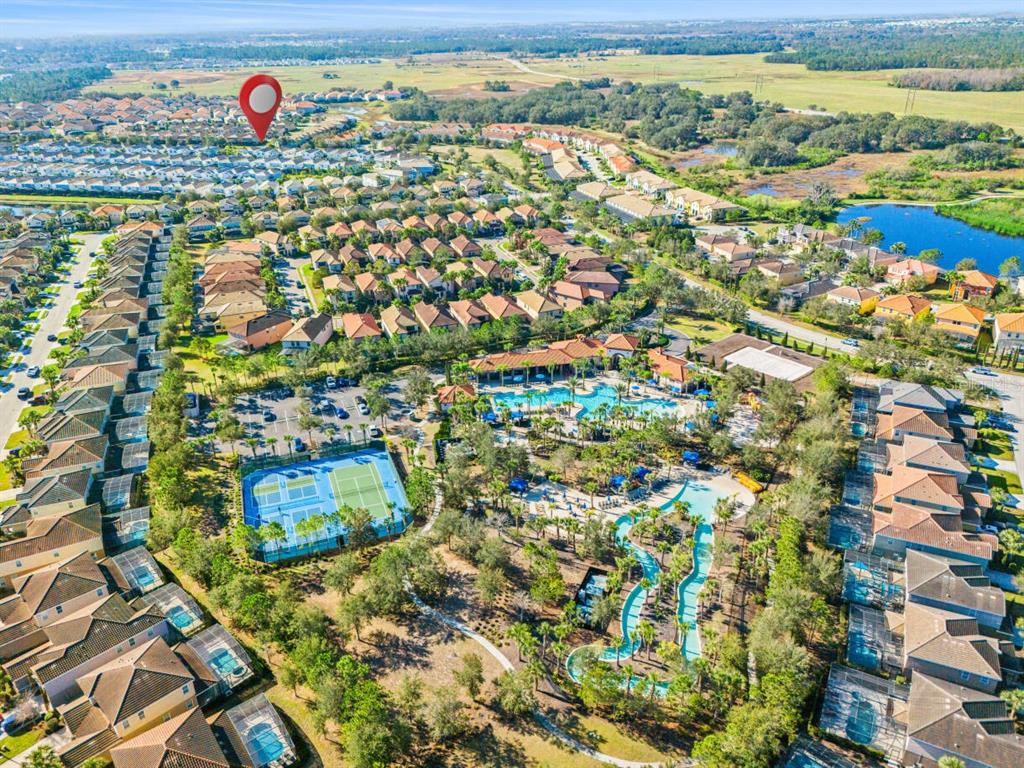 Aerial view of a residential neighborhood featuring a community pool, lazy river, and tennis courts — 5405 MISTY OAK CIRCLE, DAVENPORT, FL