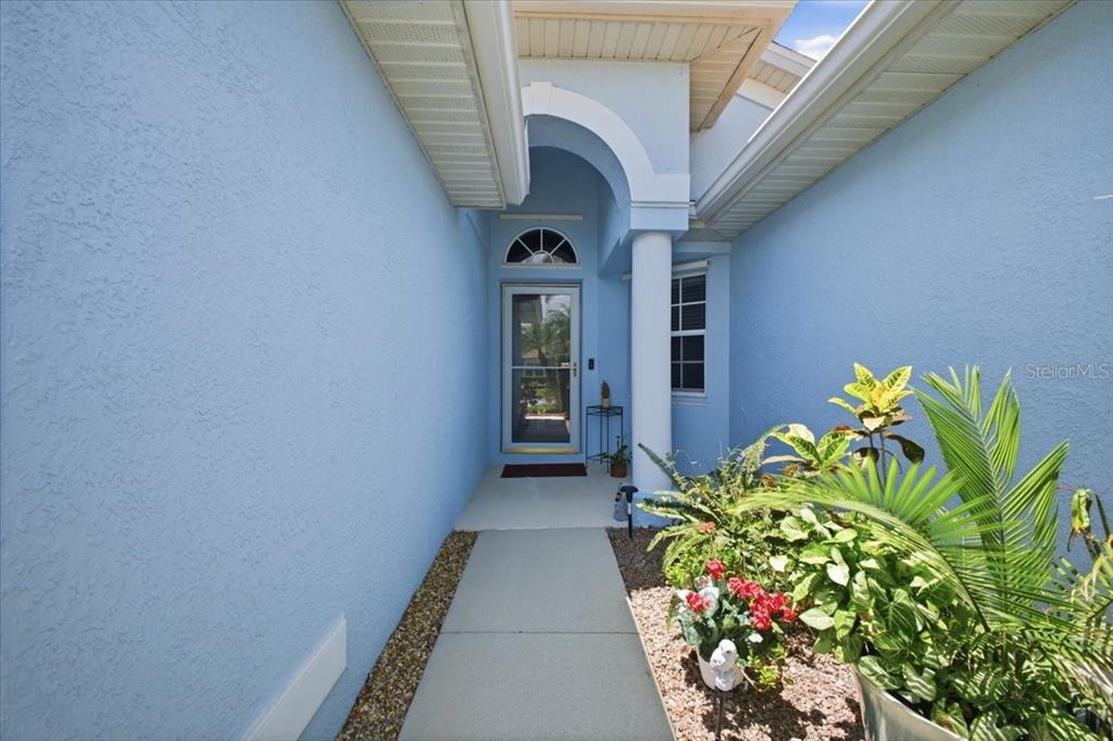 A light blue exterior entryway features a concrete walkway, a glass storm door, and landscaping — 5231 LANSDOWNE WAY, PALMETTO, FL