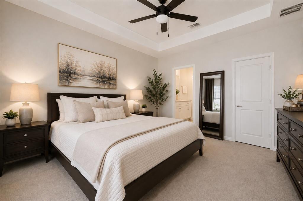 A bedroom features a dark wood bed frame, matching nightstands, a ceiling fan, and carpet — 31398 ANCIENT SAGE ROAD, WESLEY CHAPEL, FL