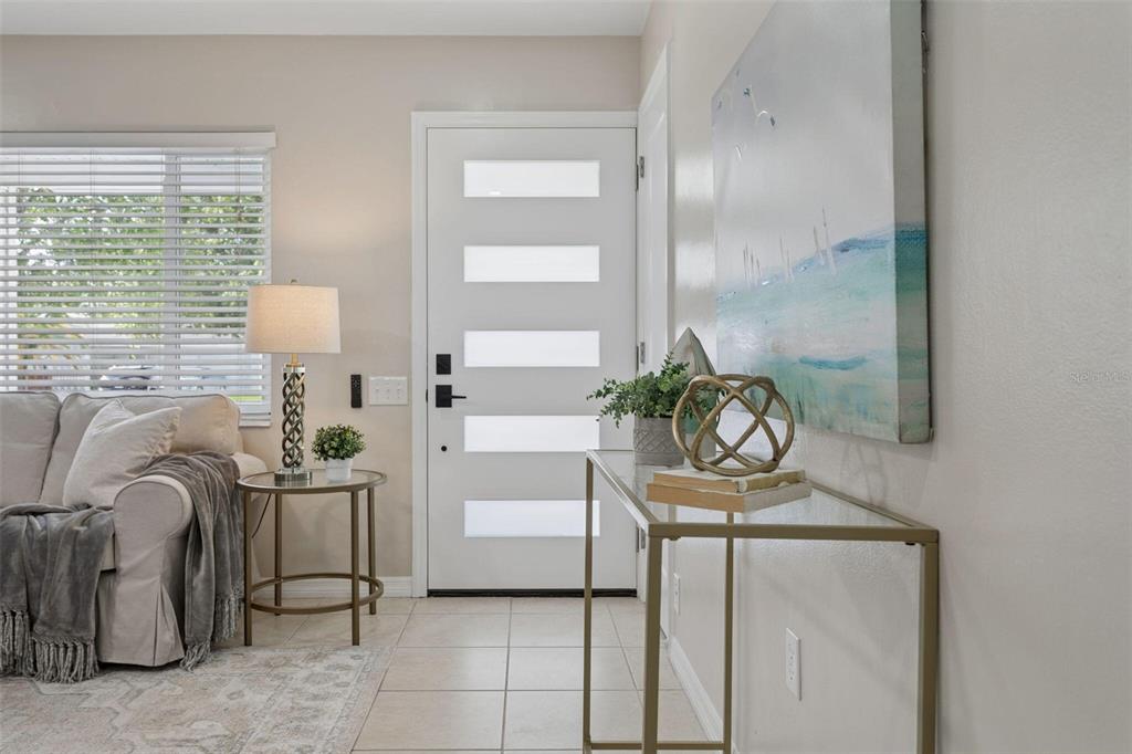 An entryway features a white door with horizontal glass panels, a console table, and furniture — 10926 TEMPLE AVENUE, SEMINOLE, FL