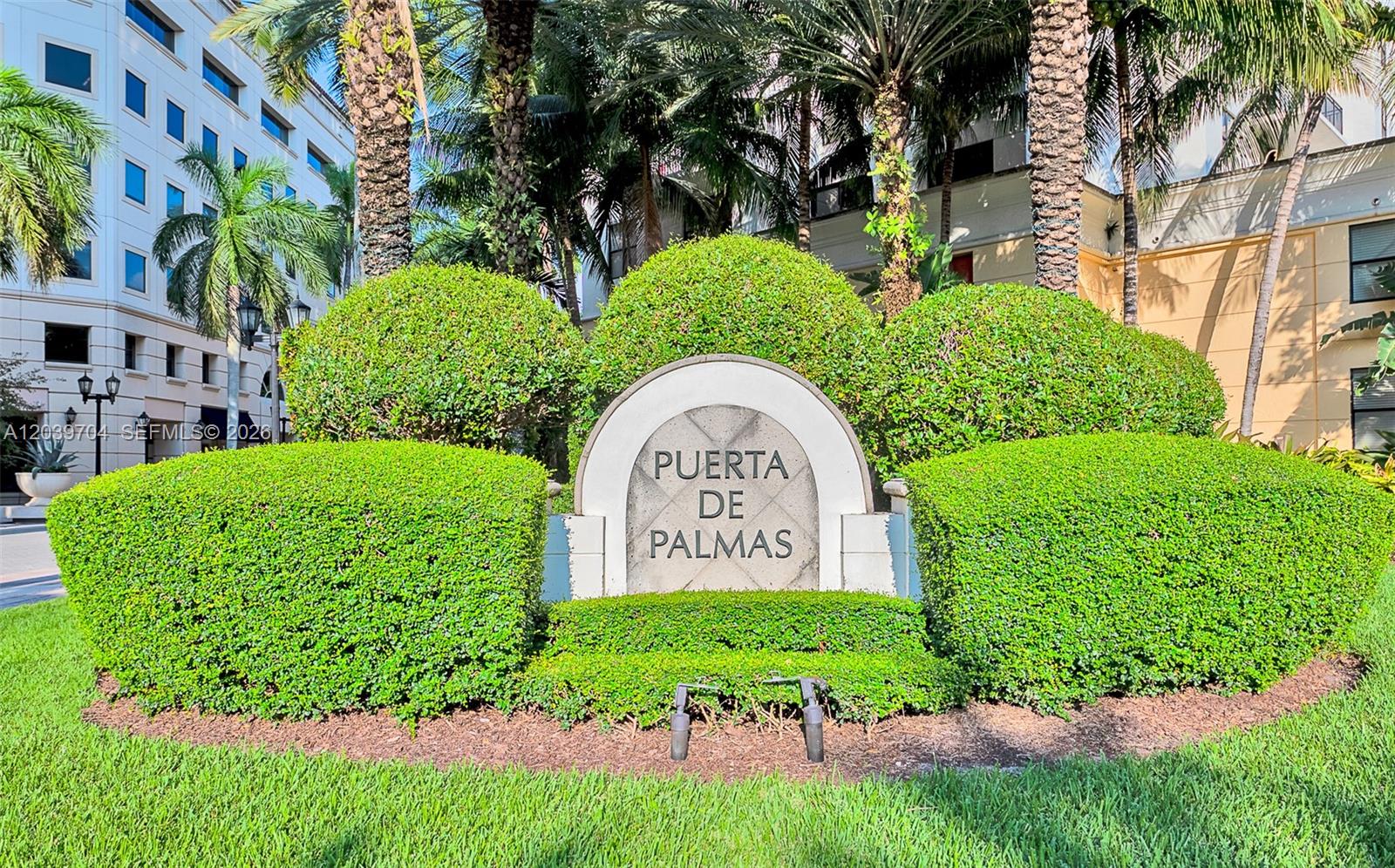 A stone sign for Puerta de Palmas is surrounded by manicured hedges and palm trees — 888 S Douglas Rd # 910, Coral Gables FL 33134, CORAL GABLES, FL