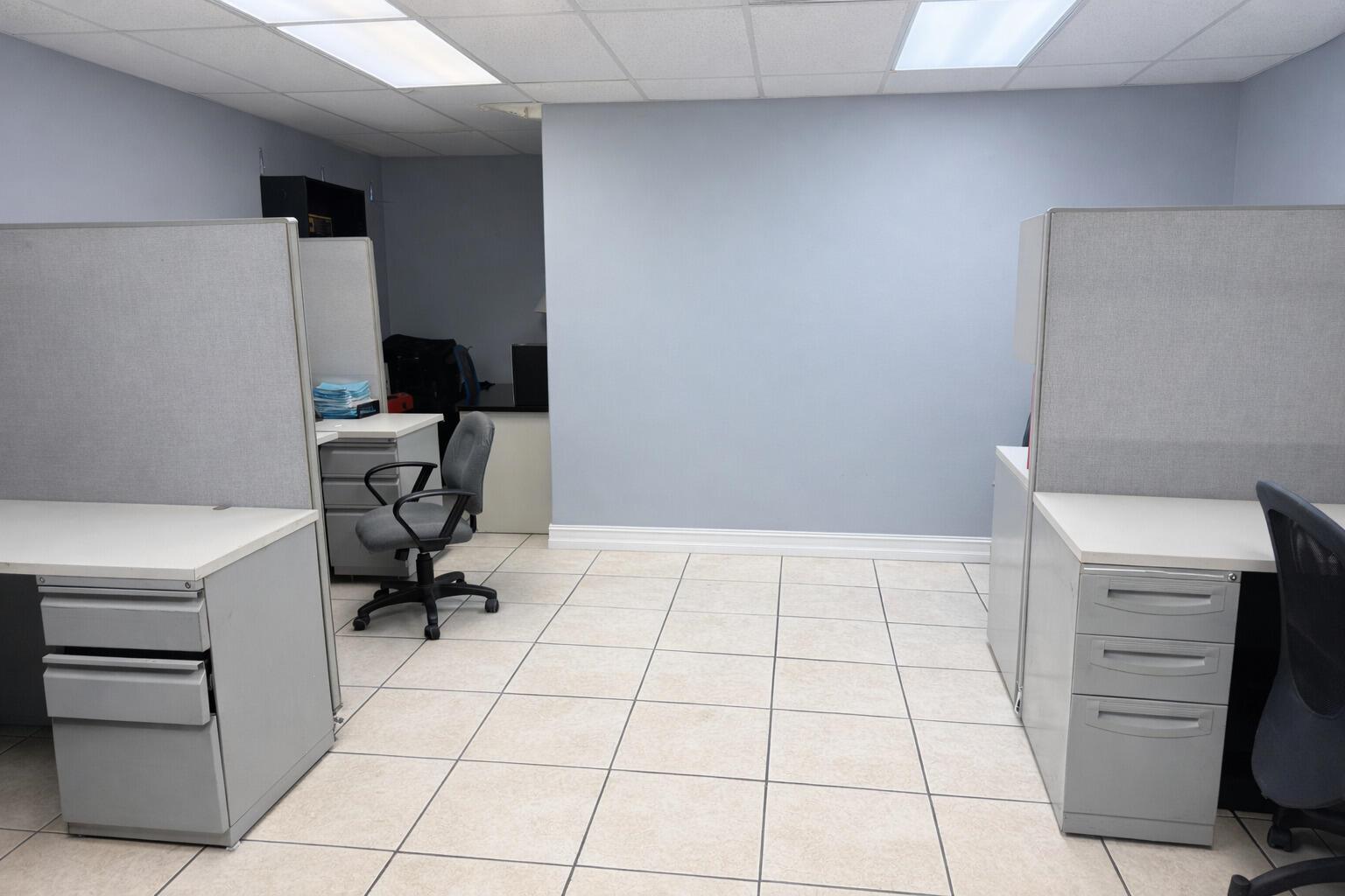 An office space features two grey cubicles with white desks and tiled flooring — 4560 Us Highway 1, Vero Beach FL 32967, VERO BEACH, FL