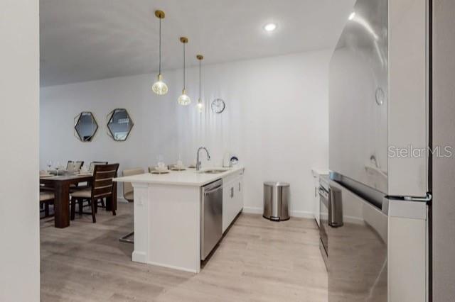 A modern kitchen features a white island with pendant lights and stainless steel appliances — 209 FAMAGUSTA DRIVE, DAVENPORT, FL