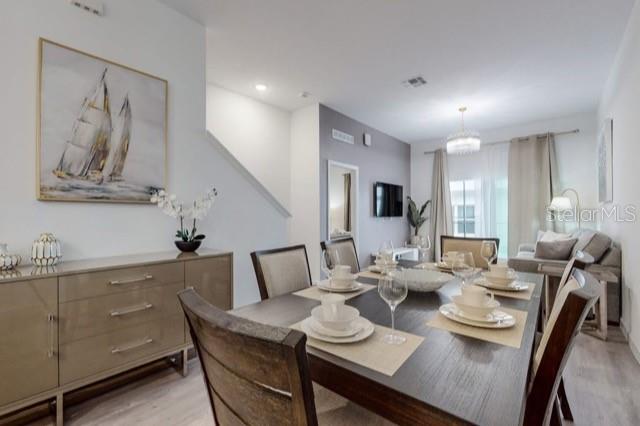 A dining room features a dark wood table, matching chairs, and a large sailboat painting — 209 FAMAGUSTA DRIVE, DAVENPORT, FL