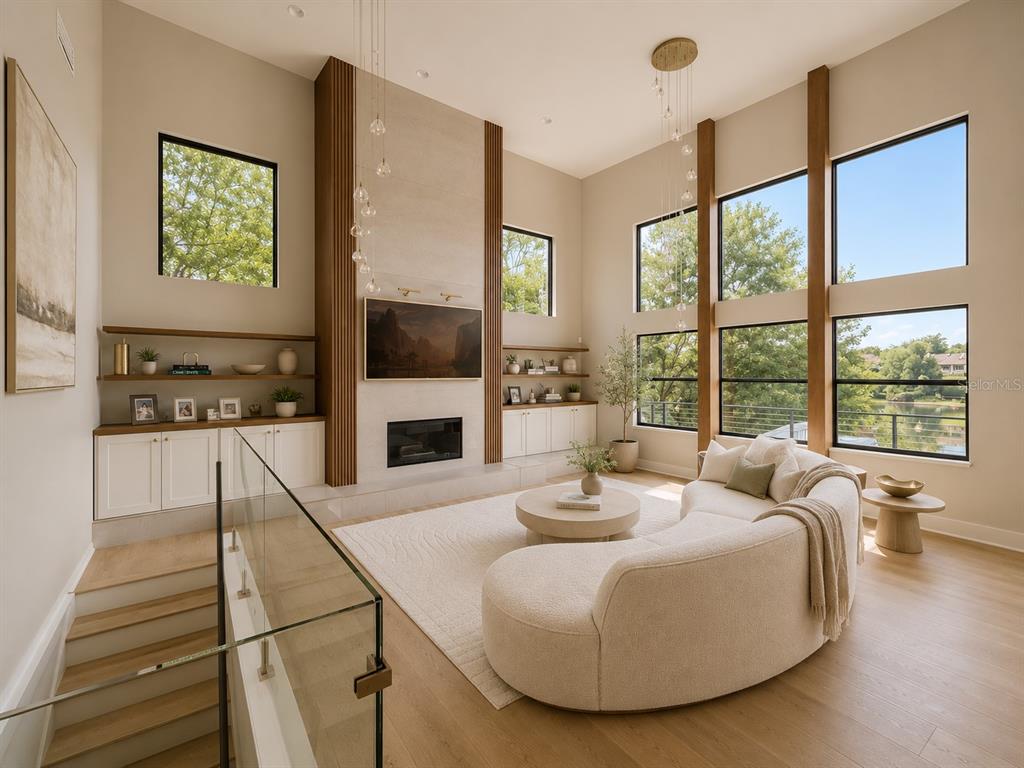 A modern living room features a curved sofa, a fireplace, and floor-to-ceiling windows — 7826 PINE HAVEN COURT, ORLANDO, FL
