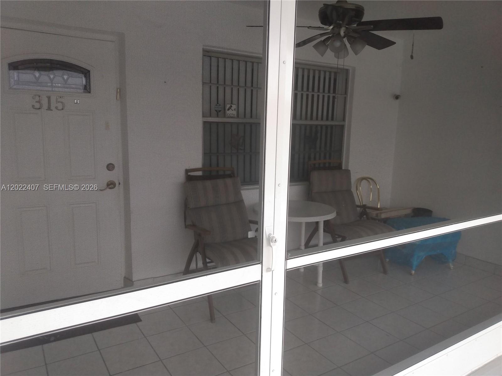 A covered patio features tiled flooring, a ceiling fan, and a small table with chairs — 581 Blue Heron Dr # B, Hallandale Beach FL 33009, HALLANDALE BEACH, FL
