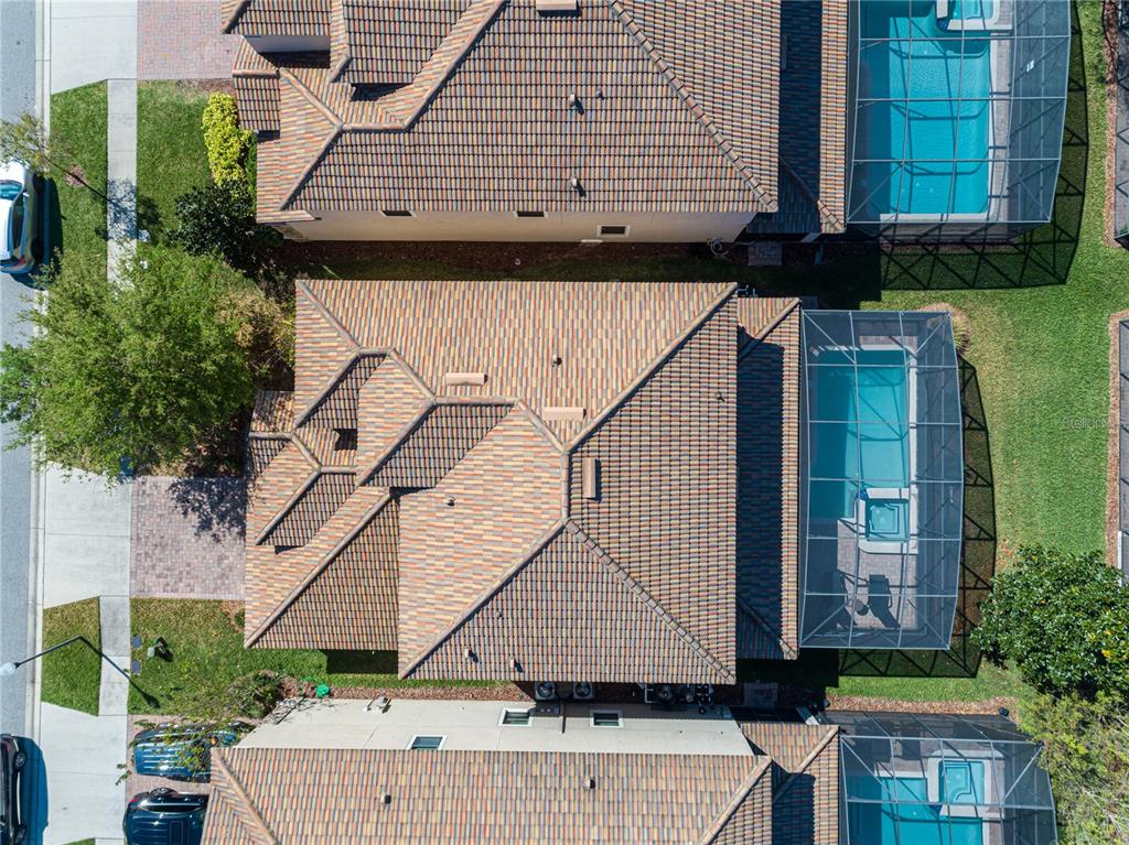 An aerial view shows a house with a tiled roof and a screened-in swimming pool — 9024 SHADOW MOUNTAIN STREET, DAVENPORT, FL