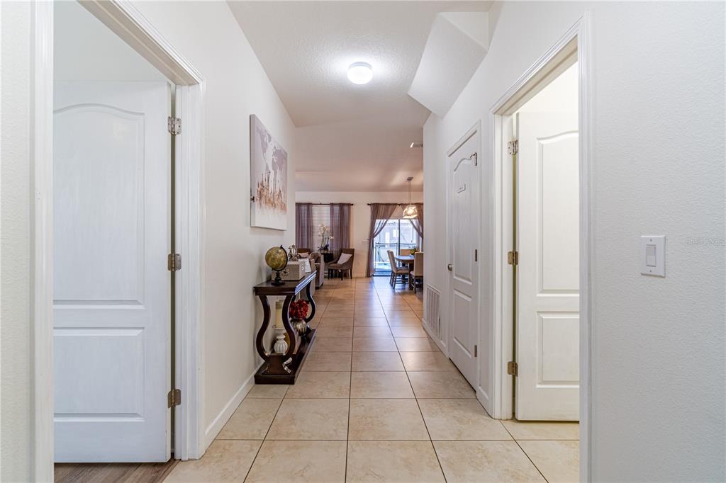 A tiled hallway leads from the entryway toward a dining area and living room — 9024 SHADOW MOUNTAIN STREET, DAVENPORT, FL