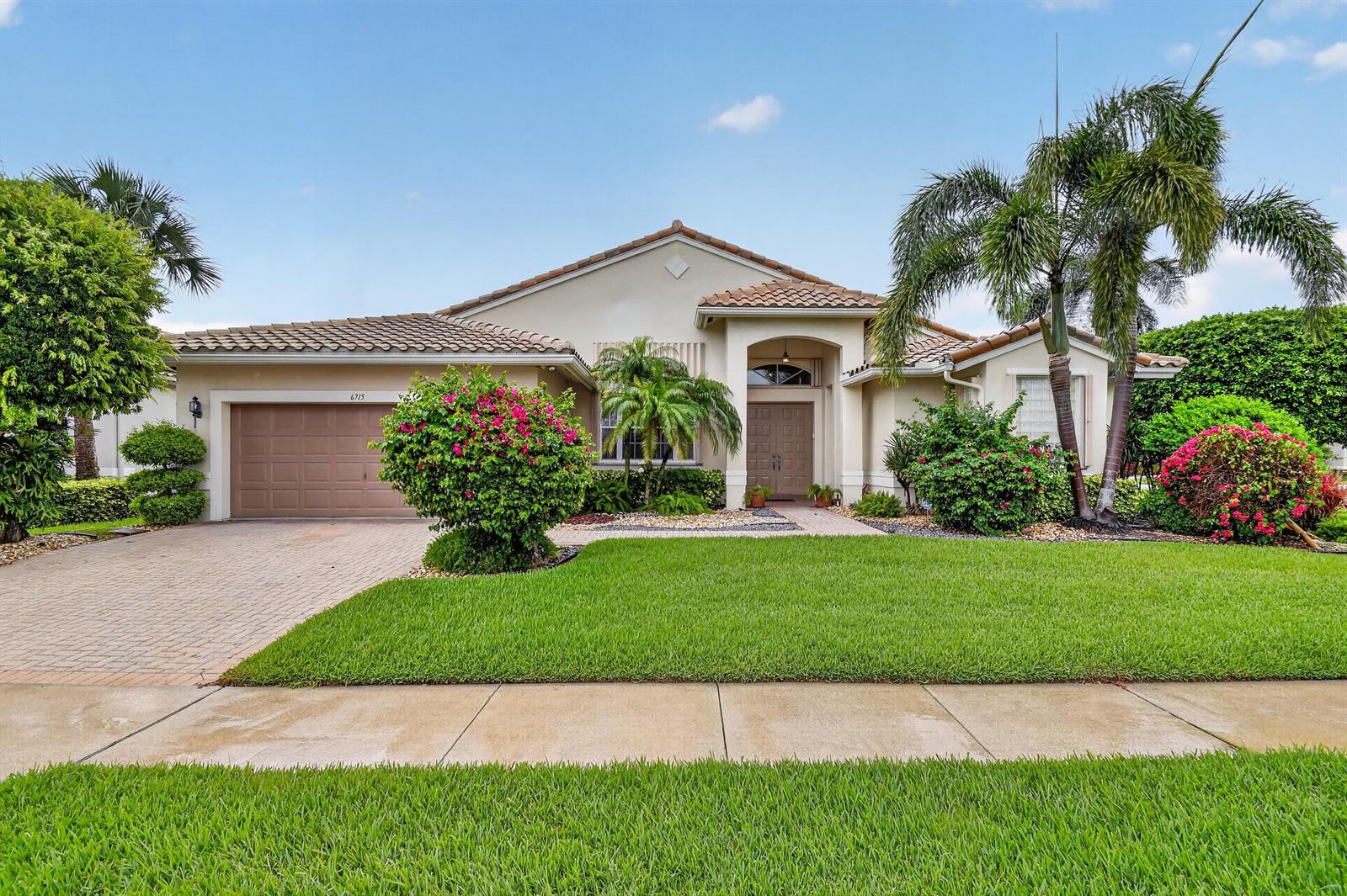 A single-story house with a tan stucco exterior, a tile roof, and a paved driveway — 6715 Chimere Terrace, Boynton Beach FL 33437, BOYNTON BEACH, FL