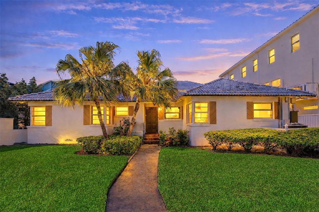 A single-story house with a tiled roof, palm trees, and a walkway at dusk — 18206 SUNSET BOULEVARD, REDINGTON SHORES, FL