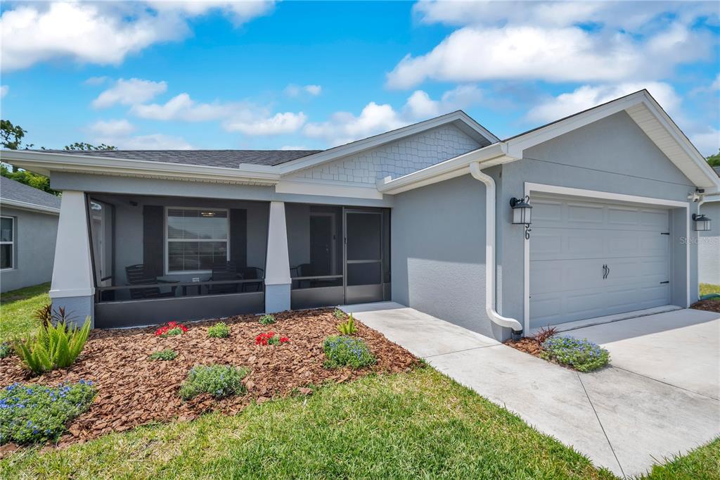 A single-story house with a gray exterior, a screened-in porch, and a two-car garage — 2096 GOLDEN BEAK DRIVE, EAGLE LAKE, FL
