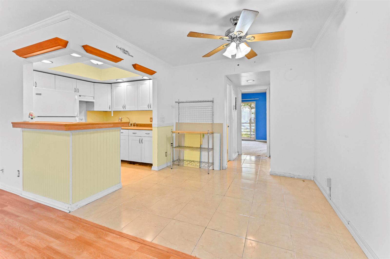 A kitchen with white cabinets and a breakfast bar opens to a tiled dining area — 259 Newport P, Deerfield Beach FL 33442, DEERFIELD BEACH, FL