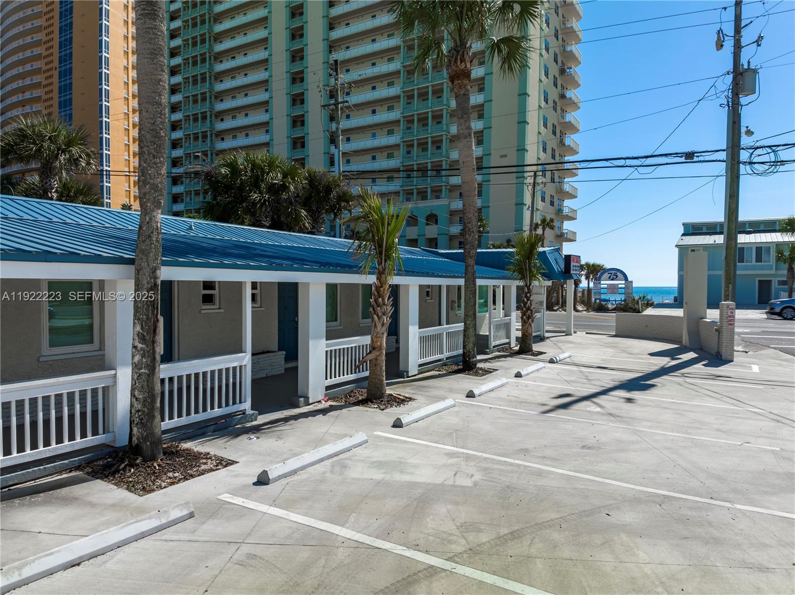 A single-story building with a blue metal roof sits beside a parking lot — 17784 Front Beach Rd # 10, Panama City FL 32413, PANAMA CITY, FL
