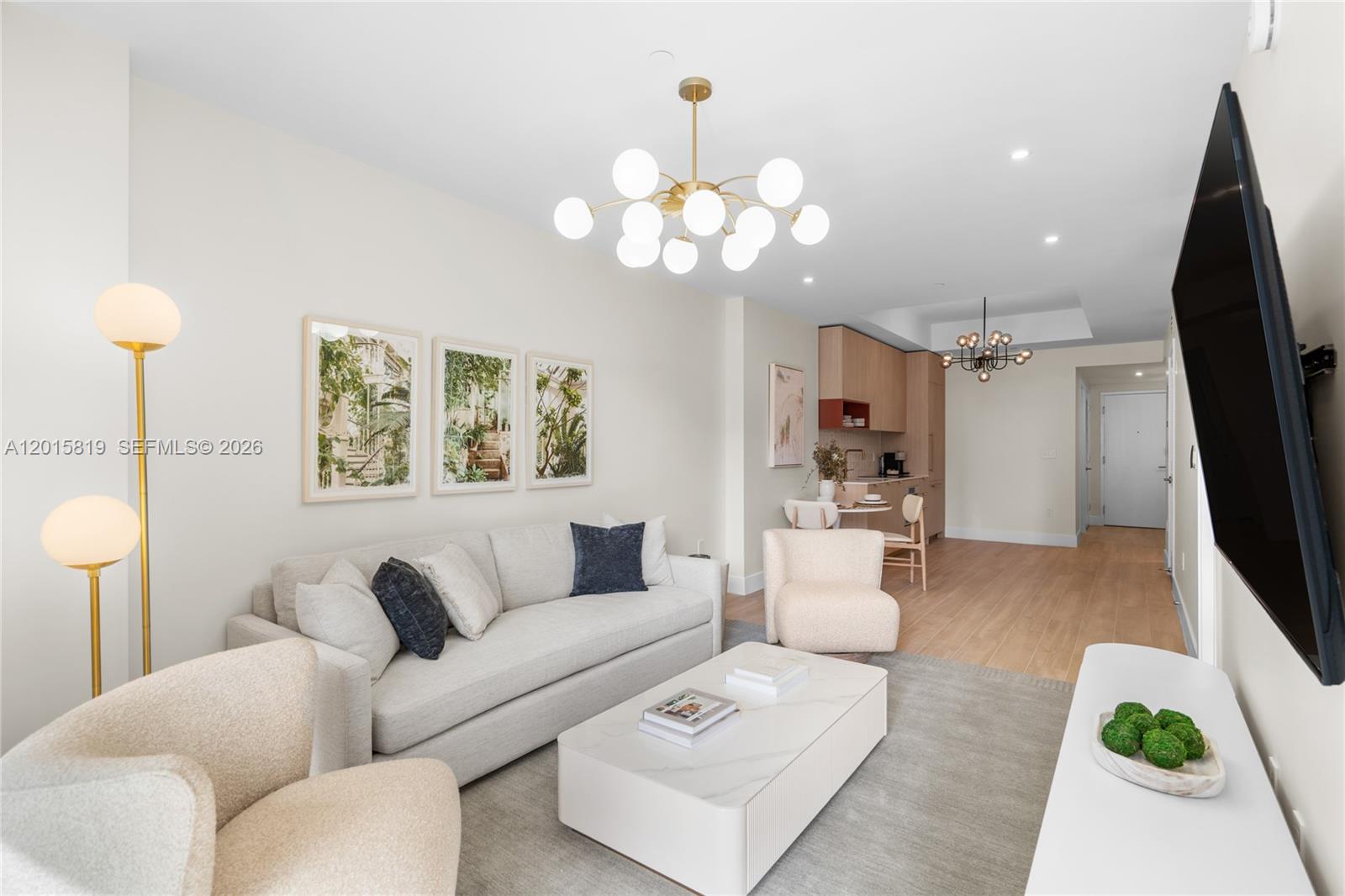 A modern living room features a white sofa, marble coffee table, and open kitchen area — 90 NE 32nd # 507, Miami FL 33137, MIAMI, FL