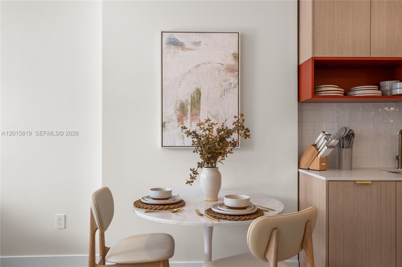 A small dining area features a round marble table, two chairs, and wall art — 90 NE 32nd # 507, Miami FL 33137, MIAMI, FL