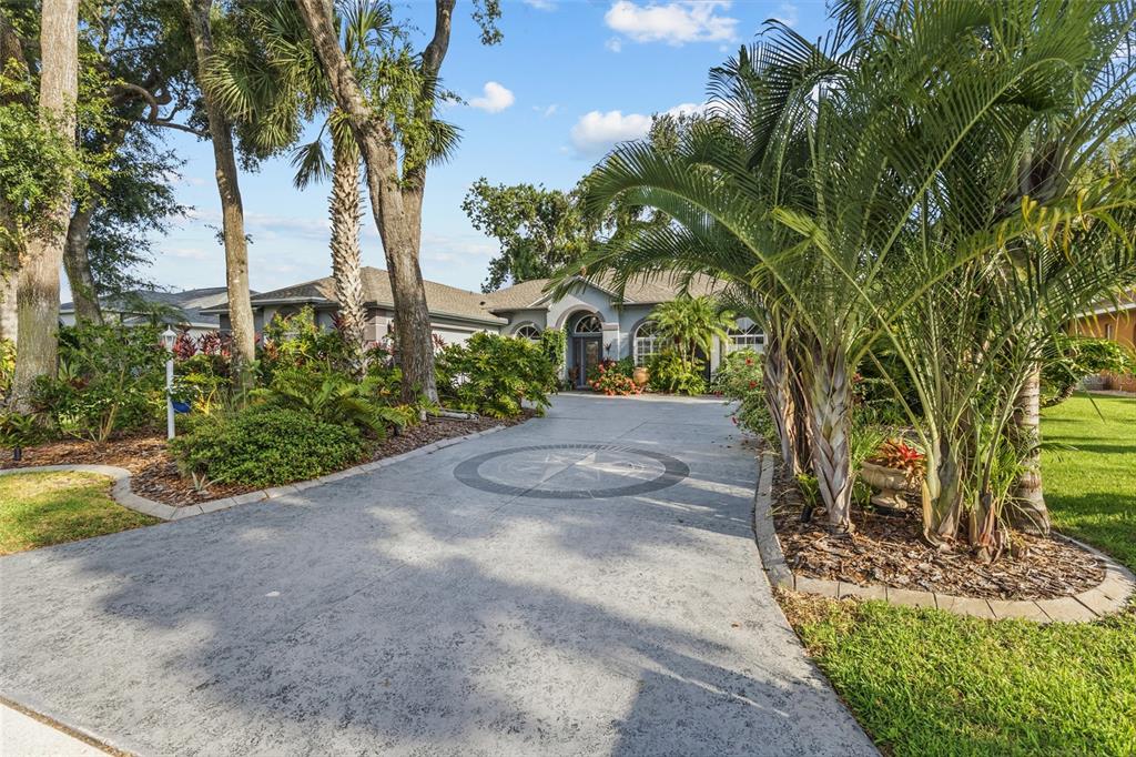 A concrete driveway with a compass rose design leads to the front of a house — 3025 RIVER WOODS DRIVE, PARRISH, FL