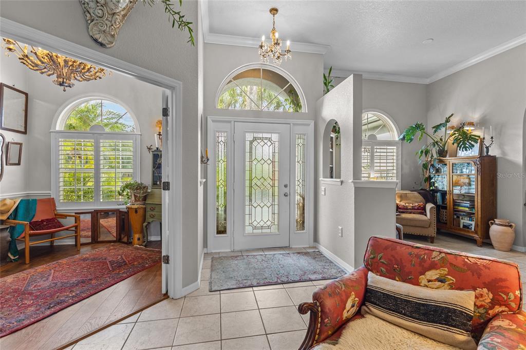 A tiled entryway features a glass-paneled front door, arched windows, and an adjacent sitting room — 3025 RIVER WOODS DRIVE, PARRISH, FL
