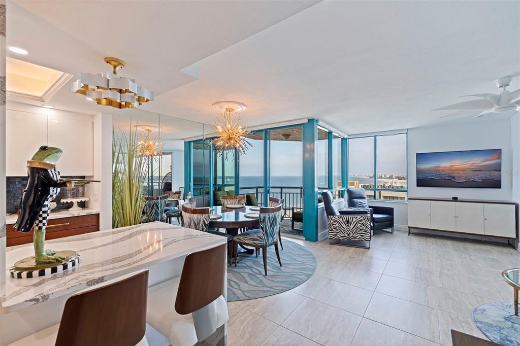 An open-concept living and dining area features ocean views, modern lighting, and a kitchen island — 1520 GULF BOULEVARD UNIT 1506, CLEARWATER BEACH, FL