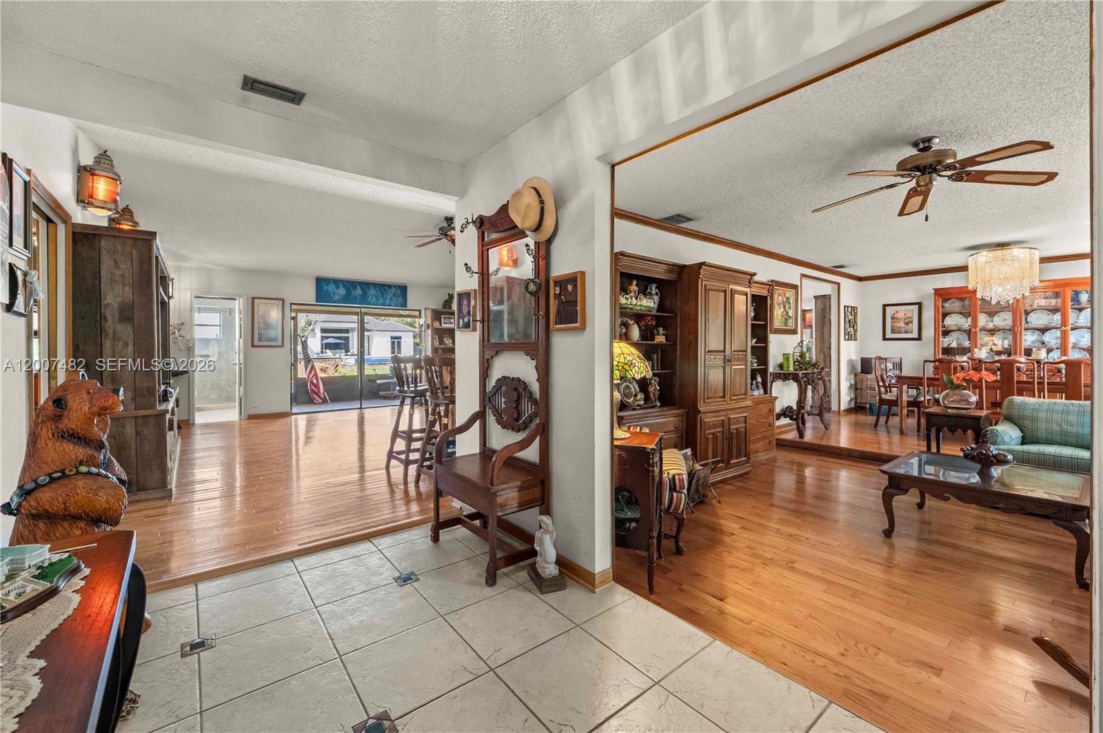 A tiled entryway leads to a living room and dining area with hardwood floors — 10651 SW 27th St, Davie FL 33328, DAVIE, FL