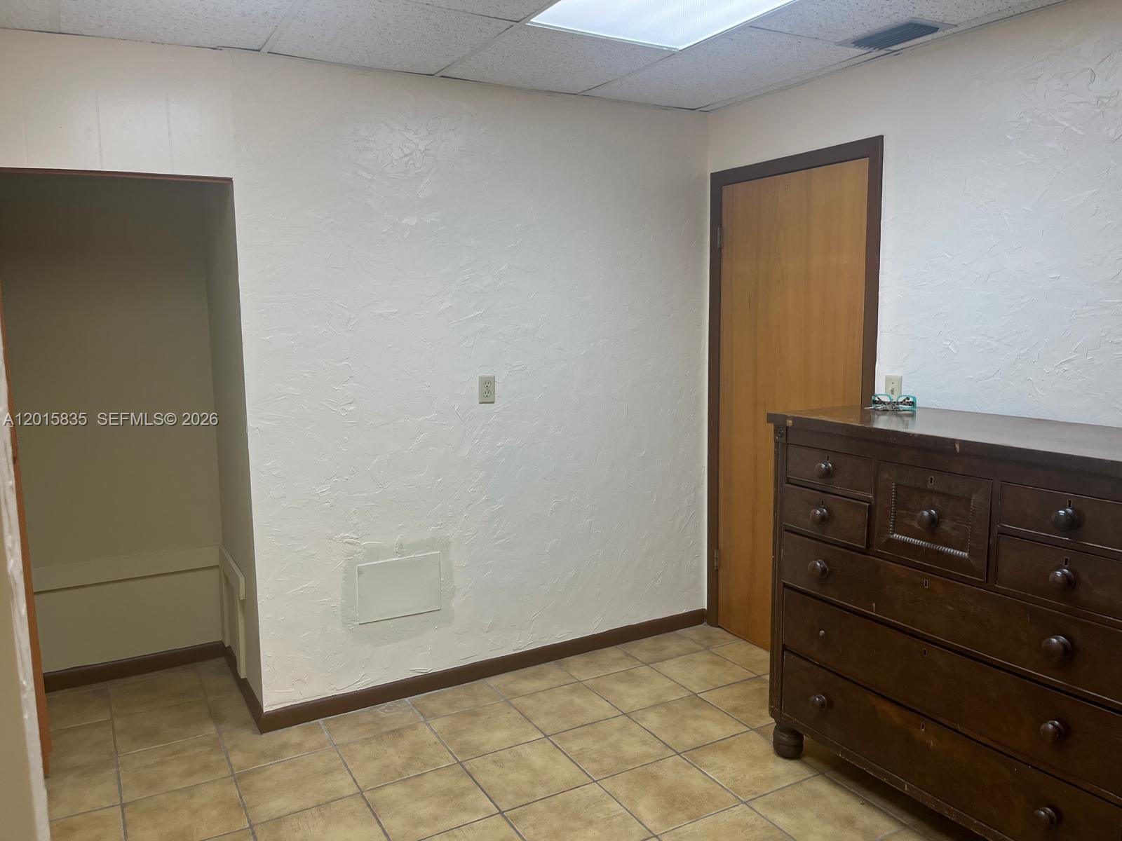 A small waiting area features tiled floors, two patterned chairs, and framed wall art — 1545 SW 1st St, Miami FL 33135, MIAMI, FL