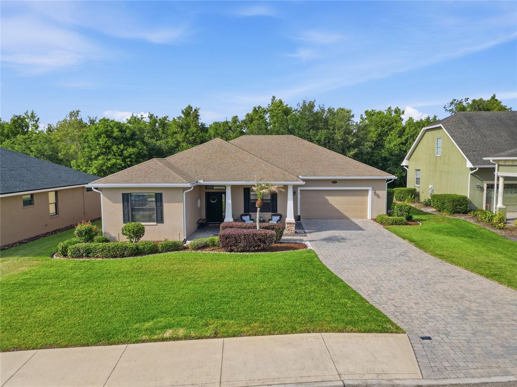 A single-story house with a tan exterior, a paved driveway, and a two-car garage — 4427 MICANOPE CRESCENT DRIVE, LAKELAND, FL