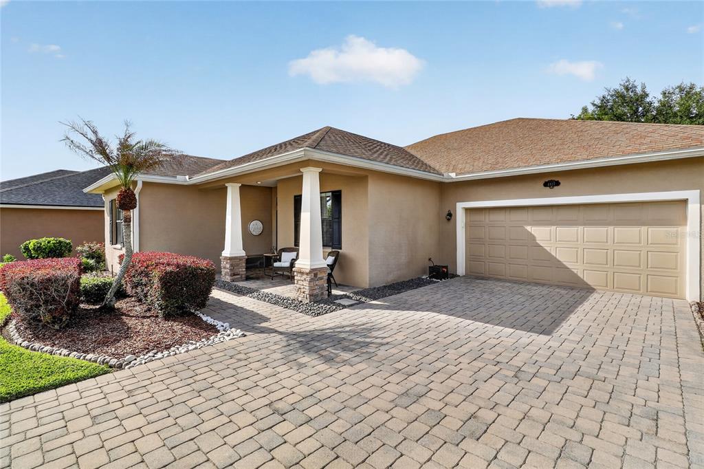 A single-story house with a tan stucco exterior, a paved driveway, and a two-car garage — 4427 MICANOPE CRESCENT DRIVE, LAKELAND, FL