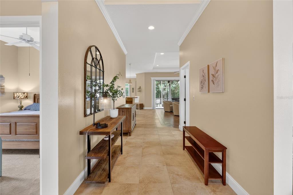 A tiled hallway leads from a bedroom entrance toward a living area and outdoor patio — 4427 MICANOPE CRESCENT DRIVE, LAKELAND, FL