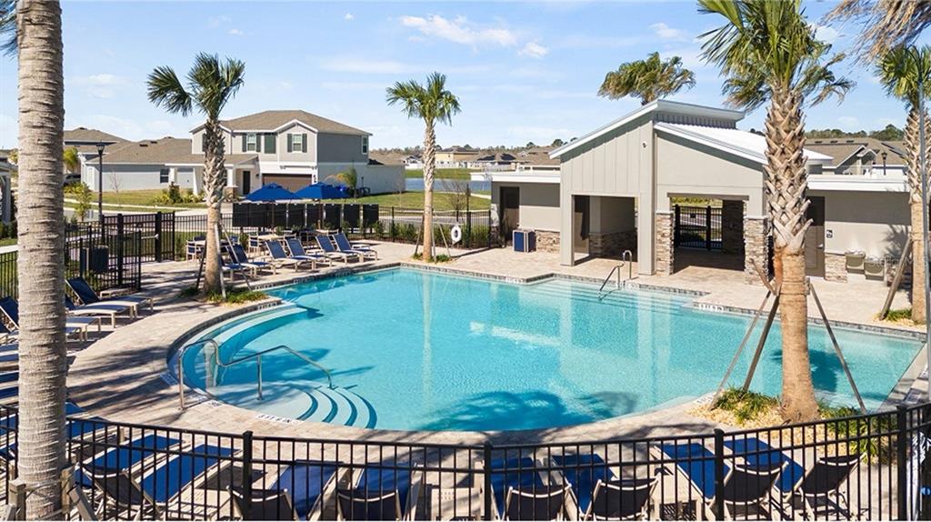 A swimming pool with lounge chairs and a covered pavilion sits in a residential community — 4939 WORCHESTER DRIVE, KISSIMMEE, FL