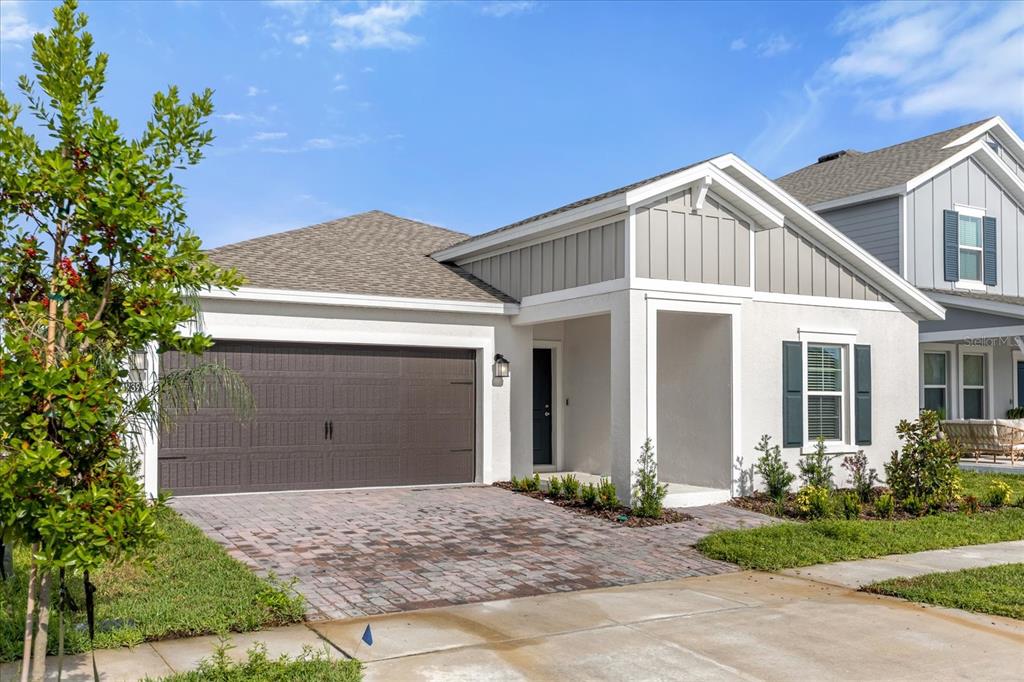 A single-story house with a brown garage door, gray siding, and a paved driveway — 4939 WORCHESTER DRIVE, KISSIMMEE, FL