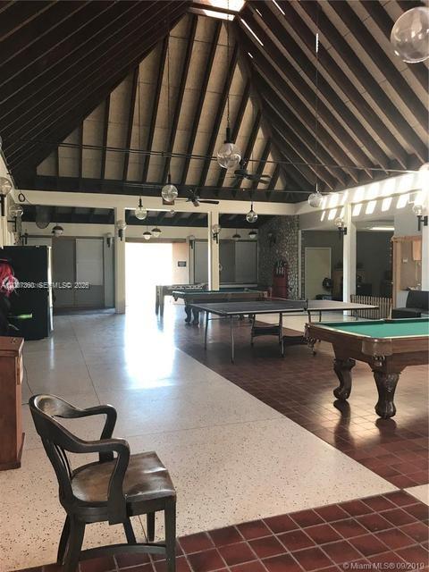 A large recreation room features a vaulted wood-beam ceiling, tile flooring, and multiple game tables — 470 N Cabbage Palm St, Clewiston FL 33440, CLEWISTON, FL