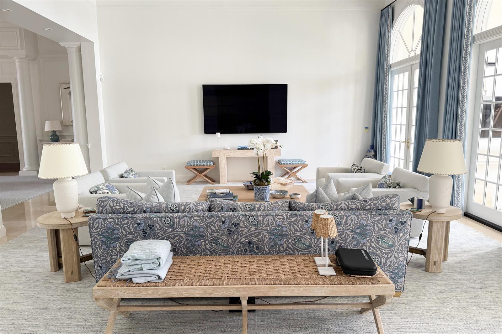A bright living room features a patterned sofa, two armchairs, and a wall-mounted television — 1494 N Lake Way, Palm Beach FL 33480, PALM BEACH, FL