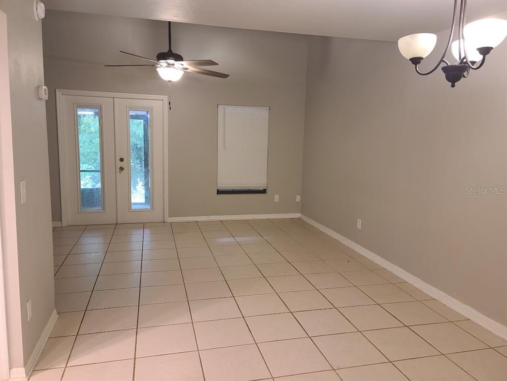 A dining area features light tile flooring, a ceiling fan, and double glass doors — 900 SW 62ND BOULEVARD UNIT B 8, GAINESVILLE, FL
