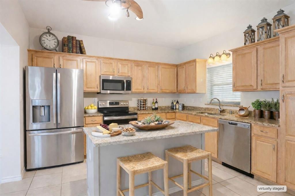 A kitchen with light wood cabinets, granite countertops, stainless steel appliances, and a central island — 4621 JOHN MOORE ROAD, BRANDON, FL