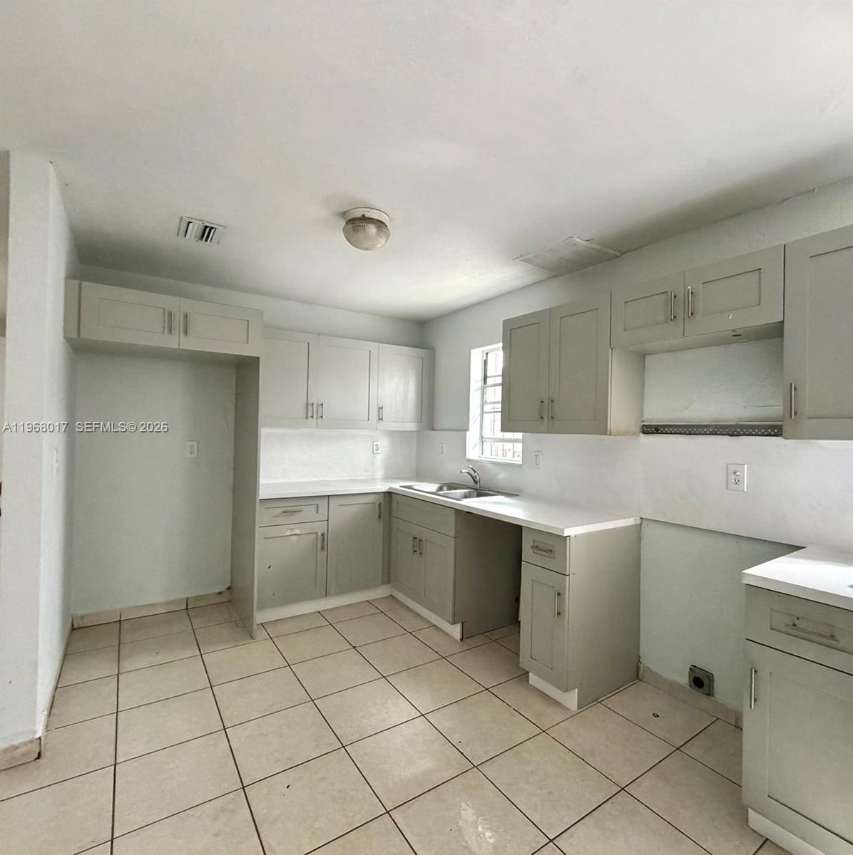 A kitchen features light gray cabinets, white countertops, and light-colored tile flooring — 137xx SW 32nd St, Miami FL 33175, MIAMI, FL