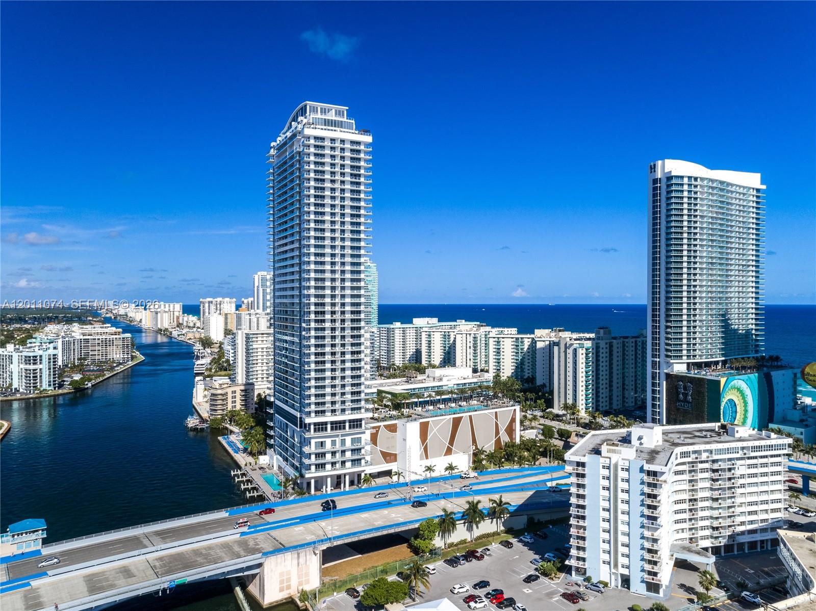 An aerial view shows two tall residential towers situated near a bridge and a waterway — 4010 S Ocean Dr # R1808, Hollywood FL 33019, HOLLYWOOD, FL