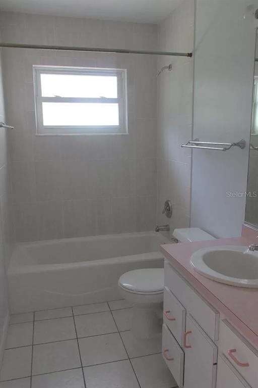 A bathroom features a white tiled tub-shower combo, a toilet, and a pink vanity countertop — 2911 BENTLEY STREET, SARASOTA, FL