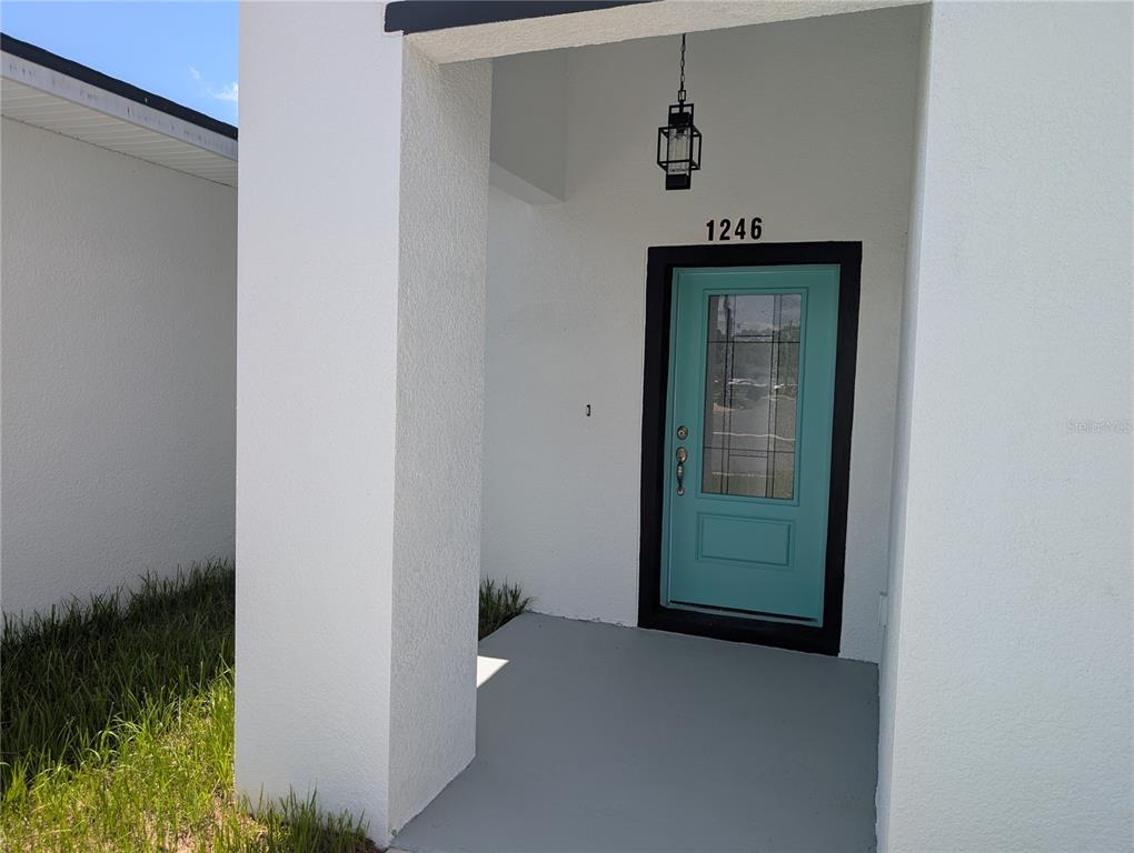 The exterior entrance features a teal front door with a glass panel and a lantern — 1246 HERSCHELL STREET, LAKELAND, FL