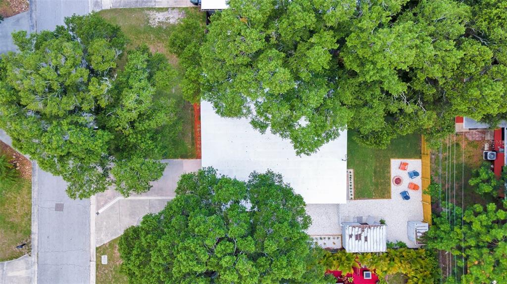 An aerial view shows a house with a white roof surrounded by large shade trees — 1555 SHIRLEY PLACE, LARGO, FL
