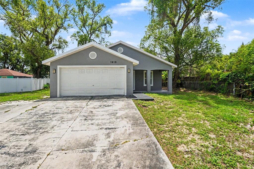 A gray single-story house with a two-car garage and a concrete driveway — 1915 E MCBERRY STREET, TAMPA, FL