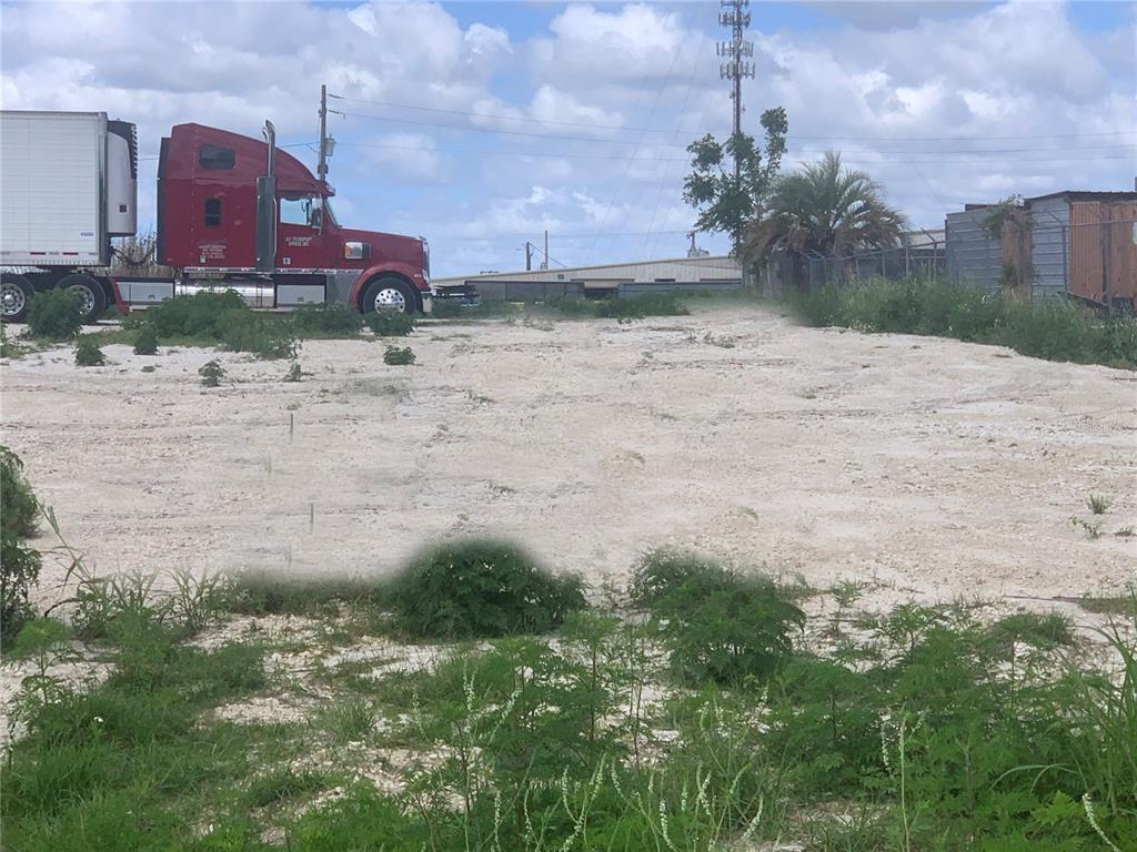 A red semi-truck is parked on a large, cleared dirt lot with sparse vegetation — 0 RHINO ROAD, LAKELAND, FL