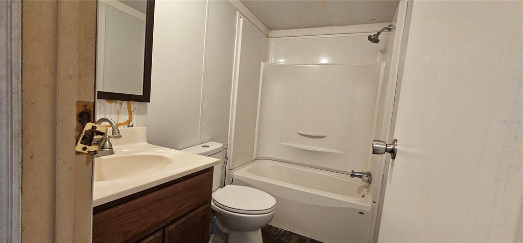A bathroom features a vanity with a sink, a toilet, and a shower-tub combination — 6605 NW 60TH COURT, OCALA, FL